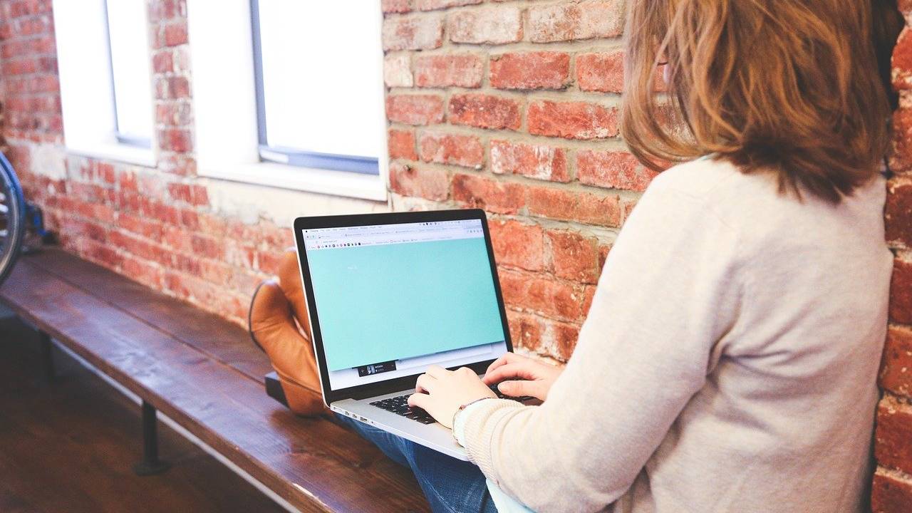 Mulher jovem estudando no computador.
