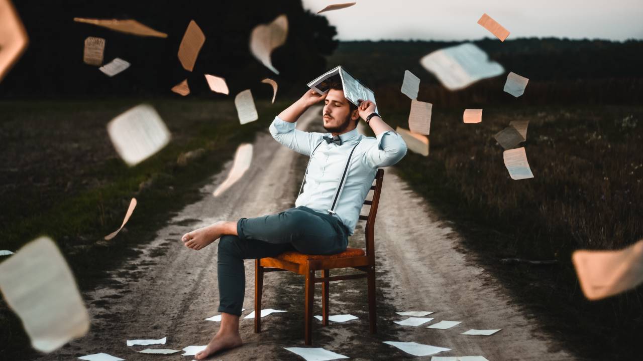 Homem descalço com muitos livros em volta