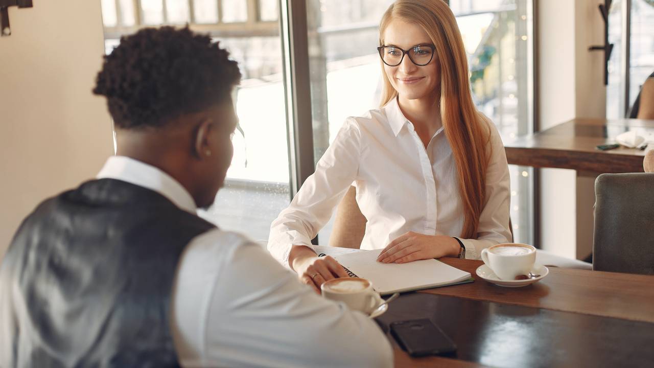 Homem e mulher conversando em uma entrevista de emprego.