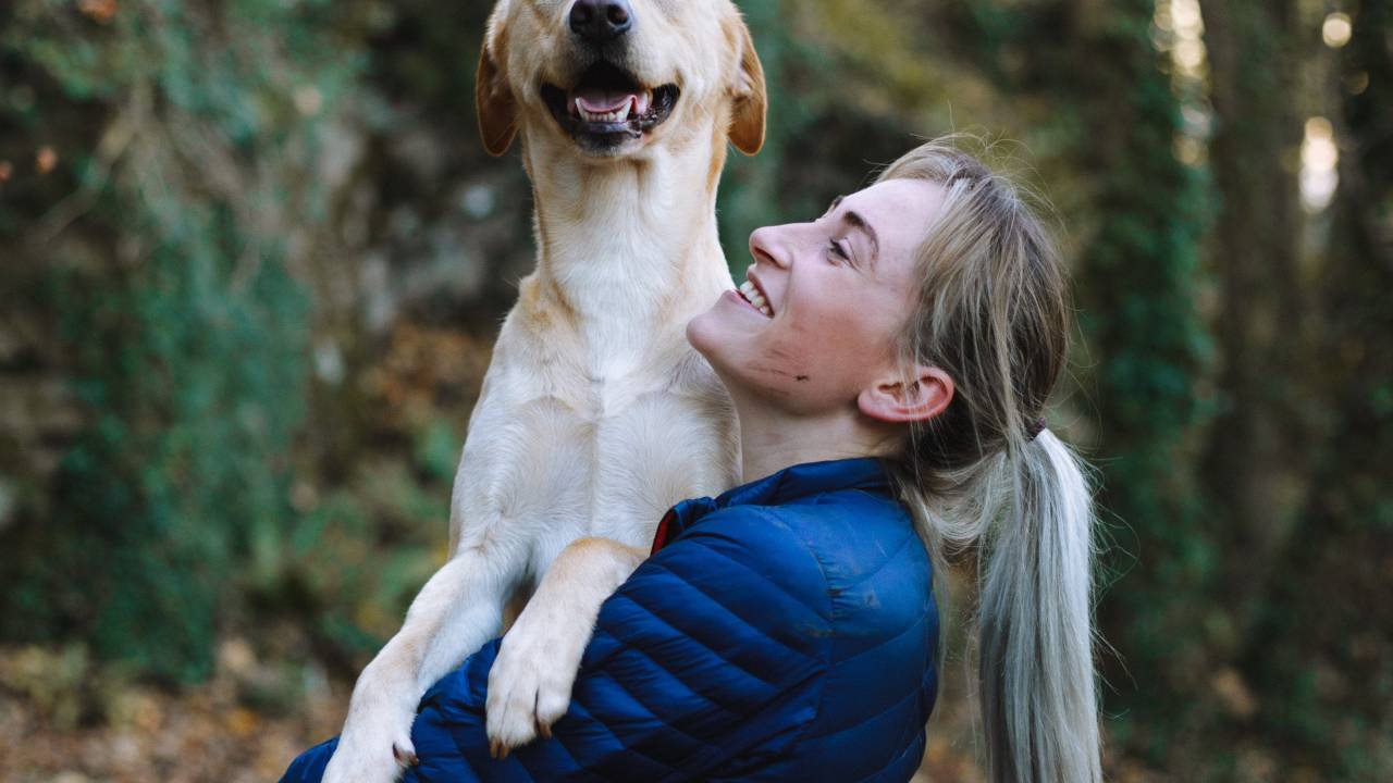 Mulher segura um cachorro grande no colo