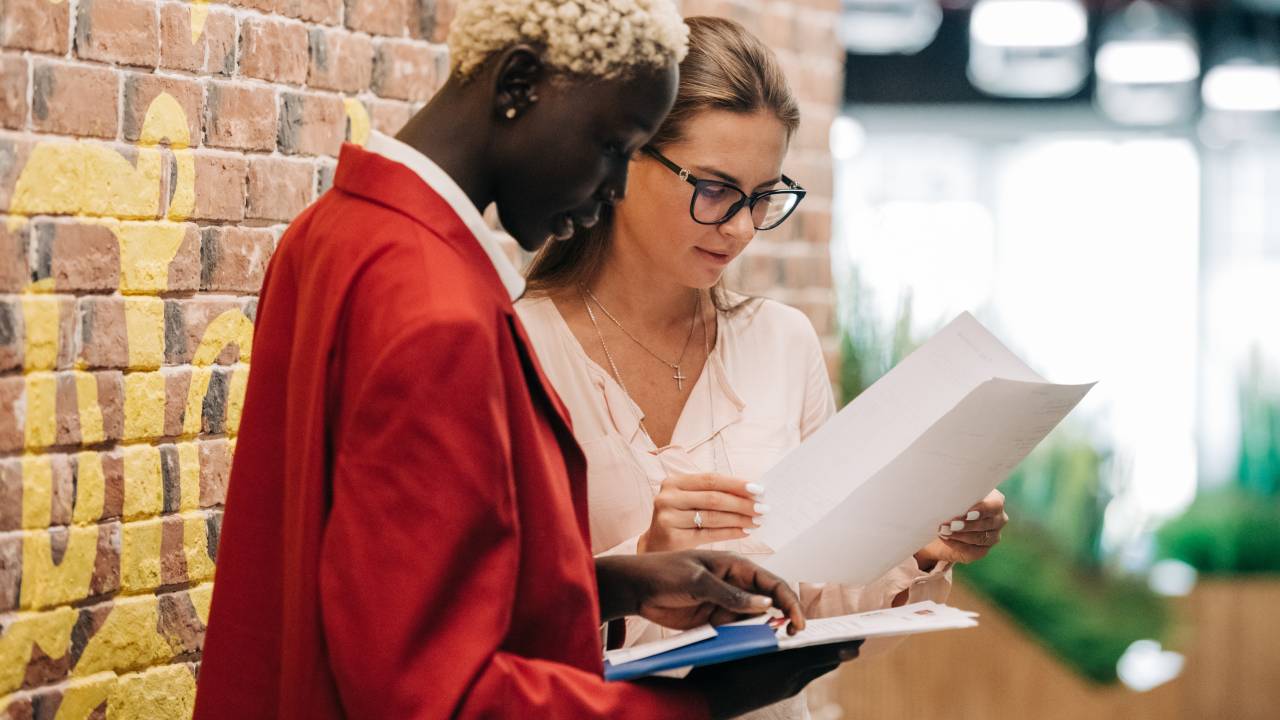 Duas mulheres conversam no corredor da empresa