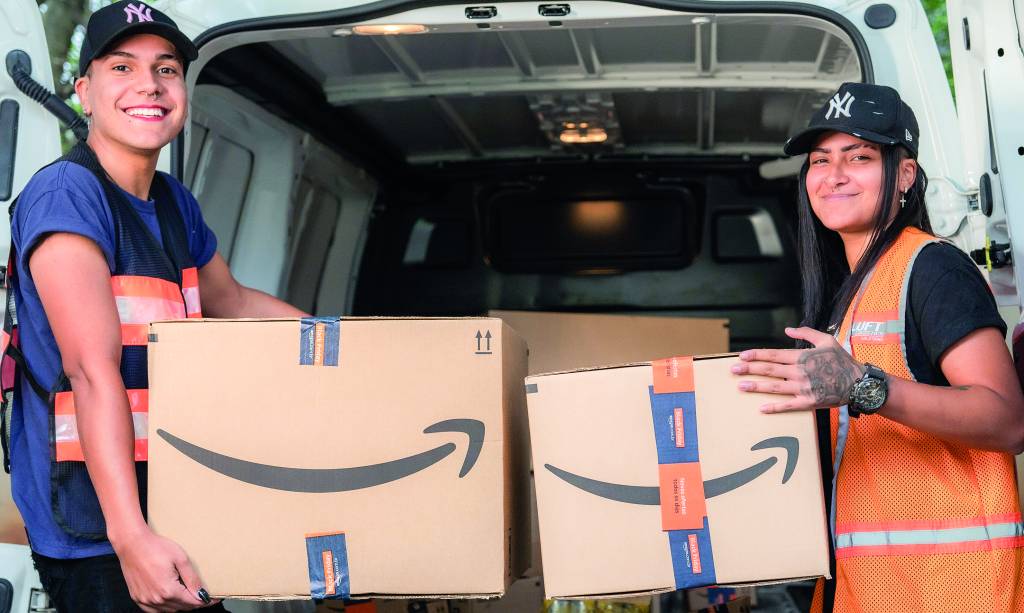 Duas pessoas seguram caixas de papelão da Amazon