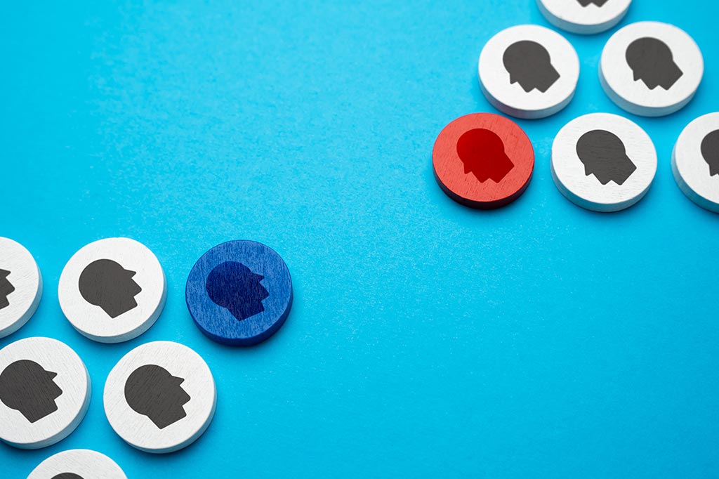 Peças de madeira dispostas em lados opostos. À frente de cada grupo de peças, há as cores azul e vermelho.